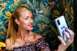 © Javier De La Torre Sebastian/Westend61 - Portrait of adult woman taking smart phone selfie at restaurant