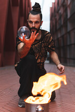 Hipster Male With Acrylic Ball Performing Fire Art On Footpath