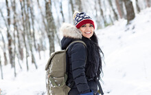 Happy Woman Wearing Knit Hat Standing On Snow During Vacations