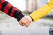 © COROIMAGE/Westend61 - Young man and woman holding hands outdoors