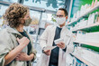 © Mareen Fischinger/Westend61 - Pharmacist recommending medicine to smiling customer in chemist shop