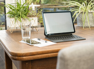 Wireless technology with pen and paper by glass on table at home