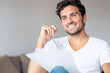 © steve brookland/Westend61 - Mid adult man with paper smiling while looking away sitting at home