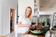 © Katharina und Ekaterina/Westend61 - Portrait of smiling woman cooking