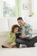 © Tetra Images/Tetra Images - Father using digital tablet with daughter (6-7)