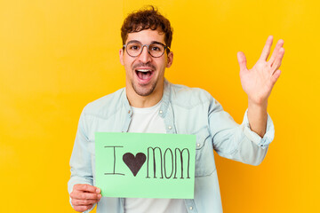 Wall Mural - Young caucasian man holding a protect our planet placard isolated receiving a pleasant surprise, excited and raising hands.