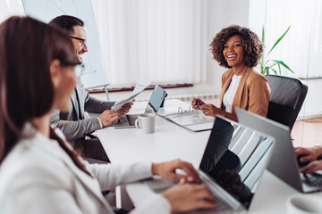 Wall Mural - Portrait of cheerful businesswoman negotiating with clients at the meeting and smiling