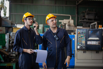 Portrait of a worker in a factory. Portrait of industrial worker indoors in factory. Young technician with hard hat.