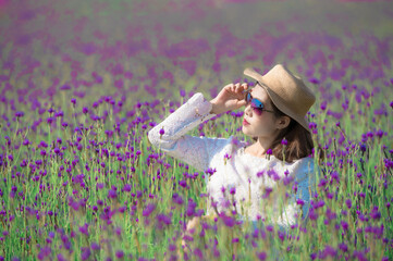 Wall Mural - Beautiful Asian woman wearing white dress in a lavender field blooming in the garden.
