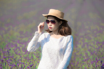 Wall Mural - Beautiful Asian woman wearing white dress in a lavender field blooming in the garden.