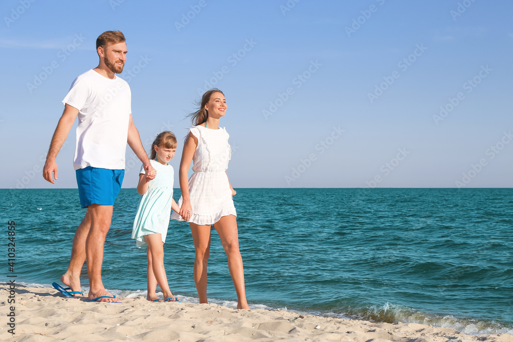 Happy family walking on sea beach