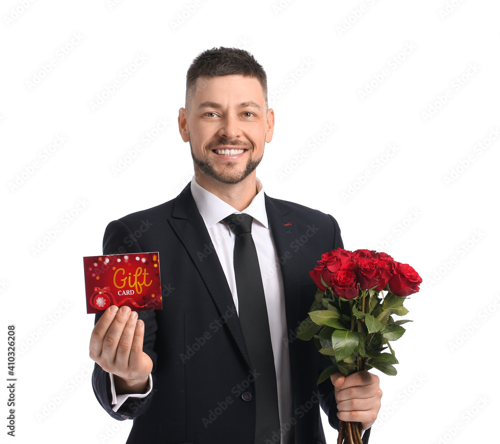 Handsome man with gift card and flowers on white background