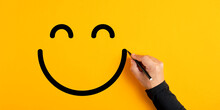 Male Hand Drawing A Smiling Happy Face Sketch On Yellow Background. Client Satisfaction, Service Or Product Evaluation