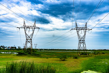 Twin Power Lines In A Green Pasture And Blue Sky