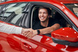 © kegfire - Happy male driver in car shaking hand with dealer