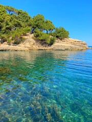 Canvas Print - Sea turquoise rippled glittering calm water, pine forest on rocky island, idyllic sunny day, scenic Mediterranean nature, blue clear sky, dream, tranquility, relax.