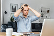 © Face Stock - Depressed young businessman holding head in hands, thinking of problem solving, looking at computer monitor. A guy made a mistake in a work