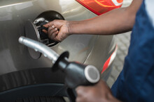 Close Up Cropped Shot Of A Gas Station Worker's Hands With Filling Gun, Ready To Refueling The Car With Gas Or Petrol At A Gas Station.