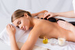 © LIGHTFIELD STUDIOS - young client getting hot stone massage in spa salon