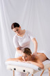 © LIGHTFIELD STUDIOS - female masseur massaging pleased woman lying on massage table in spa salon