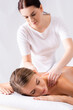 © LIGHTFIELD STUDIOS - blurred masseur massaging pleased woman on massage table in spa salon