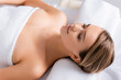 © LIGHTFIELD STUDIOS - peaceful woman with closed eyes lying on massage table in spa salon