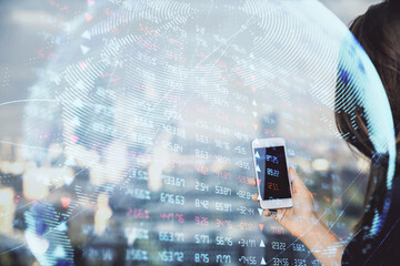 Double exposure of business theme sketch hologram and woman holding and using a mobile device.