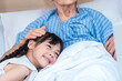 © lukyeee_nuttawut - Asian Lovely girl visit and encourage grandmother on patient bed in hospital