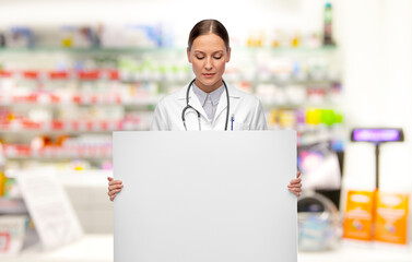 Sticker - medicine, profession and healthcare concept - female doctor holding white board over pharmacy background