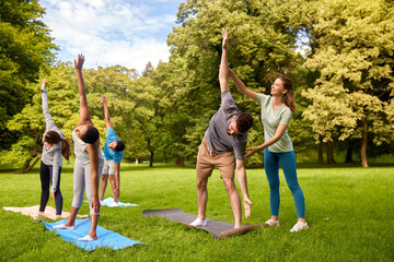 Sticker - fitness, sport and healthy lifestyle concept - group of happy people doing yoga with instructor at summer park