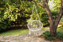Comfortable Hanging Wicker White Chair In Summer Garden. Cozy Hygge Place For Weekend Relax In Garden. Hammock Chair In Boho Style Hanging On Tree. Cozy Exterior Backyard. Concept Of Rest Outdoor. 
