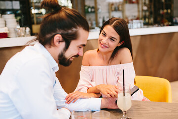 Poster - Young happy couple at a date in a coffee shop