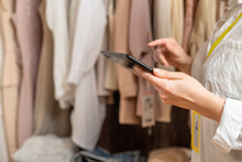 Female Entrepreneur Holding Tablet While Doing Inventory In Her Trendy Clothing Shop