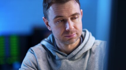 Wall Mural - close-up portrait of confident programmer working in blue office. handsome caucasian man looking at 