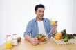 © Mallika - Smiling Asian man joyful with healthy food in the morning