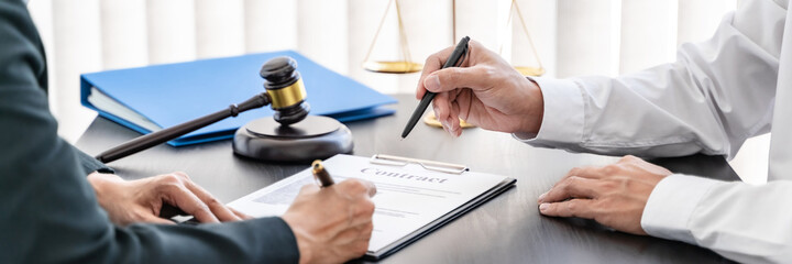  Labor law concept. Lawyer signing legal document with Judges gavel .