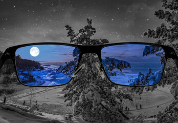 Different perception of world. Colorful view of starry night and sea coast with covered in snow fir tree and coniferous forest in the glasses. Looking through glasses.