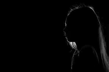 Silhouette of a young teenage girl on a black background