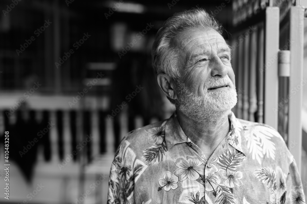 Close up of happy senior bearded tourist man smiling and thinking while looking up ready for vacation outdoors - obrazy, fototapety, plakaty 