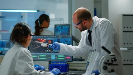 Wall Mural - team of scientists worried about virus evolution discussing in equipped laboratory pointing at compu