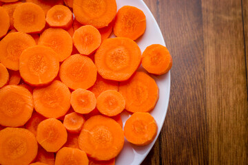 Wall Mural - Delicious food background. Raw carrots cut into mugs