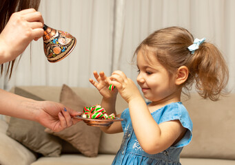 Child and traditional Ramadan candies.  Colorful sweet and baby girl.  Eid Mubarak. Kid hold plate full of sugar during Ramadan kareem (Turkish: Ramazan Bayrami).