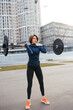 Strong woman exercising with barbell. Sports, fitness concept.