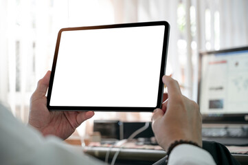 Wall Mural - cropped shot of man hands holding blank screen tablet while sitting at office desk.