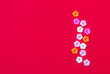 Fototapeta Kuchnia - Flower plastic button on red fabric background, valentine card background idea