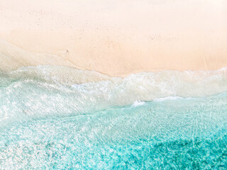 Wall Mural - Aerial view of clear sea waves and white sandy beach in summer.