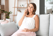 Beautiful Pregnant Woman Talking By Mobile Phone At Home