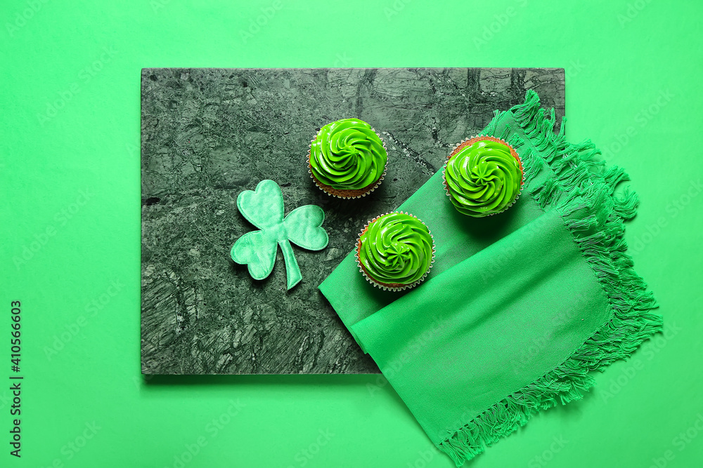 Tasty cupcakes for St. Patrick's Day on color background