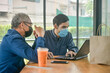 © Suriyo - Two Asian man meeting business by laptop computer in cafe, Two people wear face mask prevent coronavirus covid19