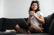 © Drobot Dean - Happy brunette young woman working with laptop and drinking coffee